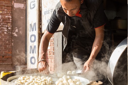 Bhaktapur, Nepal - December 4, 2014: Man preparing steamed Momos in the streetsのeditorial素材