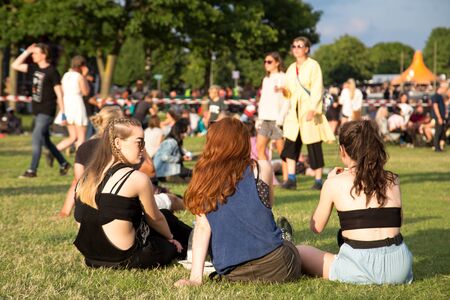 Roskilde, Denmark - June 29, 2016: People sitting on grass and enjoying sunshine and concerts at Roskilde Festivalのeditorial素材