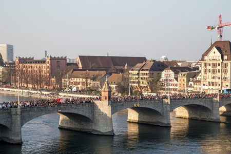 Basel, Switzerland - March 10, 2014: The bridge Mittlere Brucke filled with ddressed up people at the tradtional carnival paradeのeditorial素材