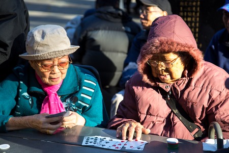 New York, United States of America - November 17, 2016: Two elderly Chinese ladies playing cards in Columbus Park in Chinatownのeditorial素材