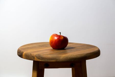 Single apple on wooden stoolの写真素材