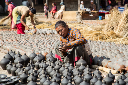 Bhaktapur, Nepal - December 5, 2014: An elderly woman sitting next to clay pots on Pottery Square.のeditorial素材