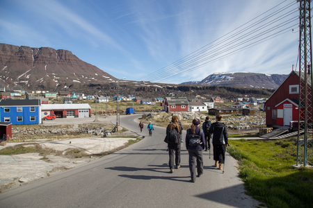 Qeqertarsuaq, Greenland - July 04, 2018: People waling on a street with colorful wooden houses.のeditorial素材