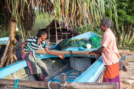 Trincomalee, Sri Lanka - July 31, 2018: Fishermen preapring their fishing net at in a fishing boat.