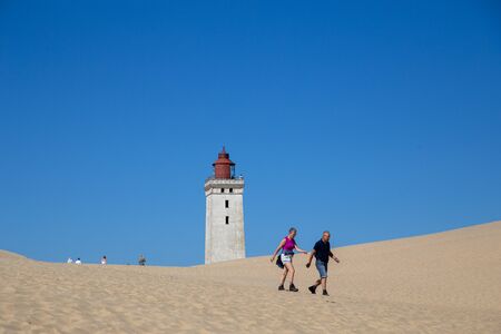 Lokken, Denmark - July 16, 2019: People at the popular Rubjerg Knude Lighthouse in Jutland.のeditorial素材