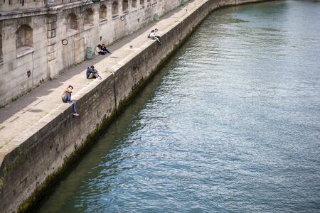 Paris, France - May 11, 2017: People sitting in the sun at the River Seine.のeditorial素材