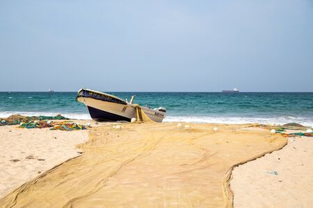 Trincomalee, Sri Lanka - August 24, 2018: A fishing boat and fishing net at the sandy beachのeditorial素材