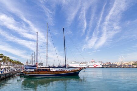 Malaga, Spain - May 24, 2019: A sailboat anchored in the harbour at the new Muello Uno district.のeditorial素材