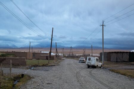 Sary-Mogul, Kyrgyzstan - October 7, 2014: Gravel road and houses in the village Sary-Mogul in South Kyrgyzstan.のeditorial素材