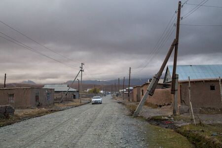 Sary-Mogul, Kyrgyzstan - October 7, 2014: Gravel road and houses in the village Sary-Mogul in South Kyrgyzstan.のeditorial素材