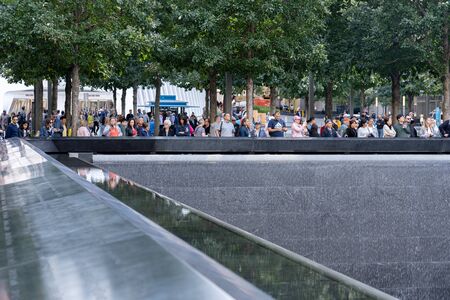 New York, United States of America - September 19, 2019: People standing at the north pool of the World Trade Center Ground Zero Memorial in Lower Manhattan.のeditorial素材