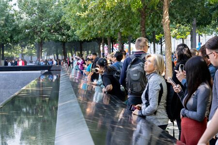 New York, United States of America - September 19, 2019: People standing at the north pool of the World Trade Center Ground Zero Memorial in Lower Manhattan.のeditorial素材