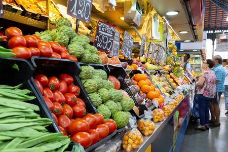 Malaga, Spain - May 24, 2019: People at fruit and vegetable stalls inside the famous Atarazanas Market.のeditorial素材