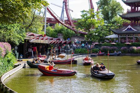 Copenhagen, Denmark - August 10, 2019: People in boats on a lake in Tivoli Gardens.のeditorial素材