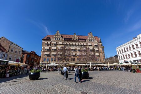 Malmo, Sweden, April 20, 2019: Historic buildings and people in cafes and restaurants on the Little Square.のeditorial素材
