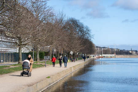 Copenhagen, Denmark - March 20, 2020: A few people enjoying walking along The Lakes on a sunny day. The has been locked down due to the corona virus.のeditorial素材