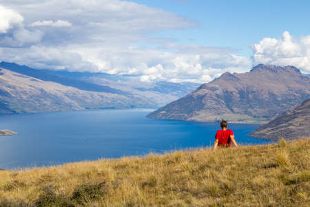 Queenstown, New Zealand - March 26, 2015: Young man enjoying the view from top of Queenstown Hillのeditorial素材