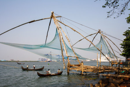Cochin, India - January 24, 2011: Famous Chinese fishing nets and fishermen in canoes.のeditorial素材