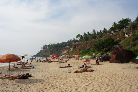 Varkala, India - February 1, 2011: People relaxing on the sand beachのeditorial素材