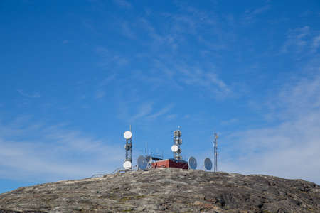 Ilulissat, Greenland - June 30, 2018: Radio and satellite antennas on a rocky hill