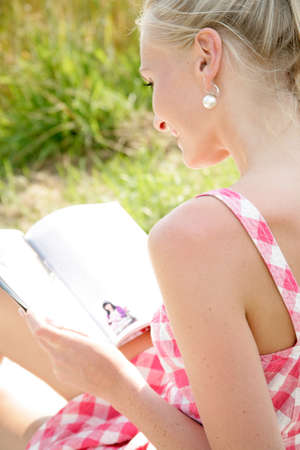 Young woman reading a magazineの写真素材