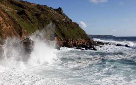 waves smashing up a fishing shack at cape cornwall