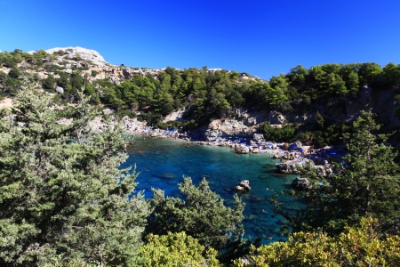 Tourists swim and play in Crystal clear waters at Anthony Quinn Bay in Greeceの写真素材