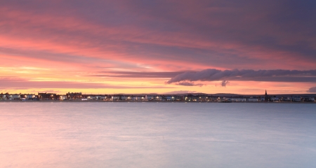 The sunsets over Weymouth seafront taken from view over the seaの写真素材