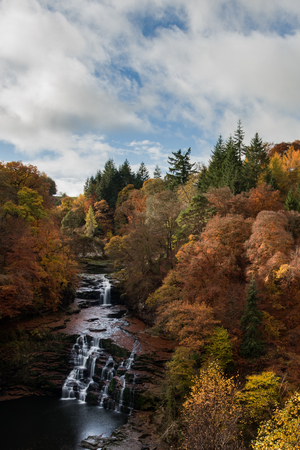 Falls of Clyde waterfall in autumn colours New Lanark, Lanarkshire, Scotlandの写真素材