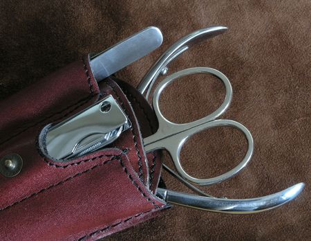 manicure tools: nail scissors, nippers, tongs and a clasp-knife placed on suede surfaceの写真素材