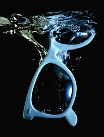sunglasses fall to the water with splashの写真素材
