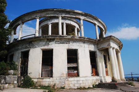ancient round blasted house with columns against blue skyの写真素材