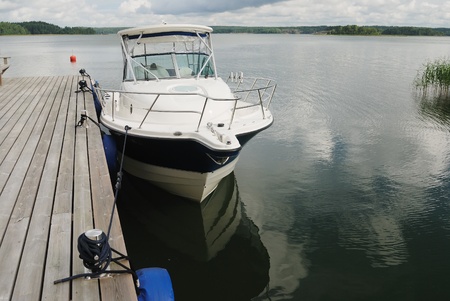 big white boat tied up at the wooden pier