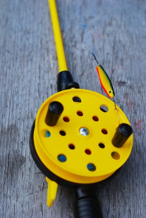 fishing rod with yellow reel on the bankの写真素材