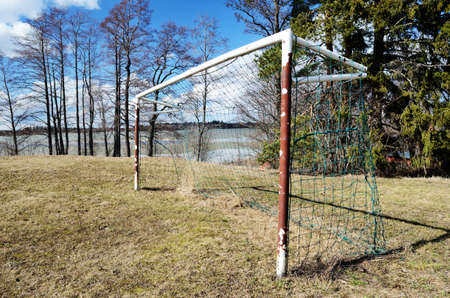 old soccer goal on the village sports field in springの写真素材