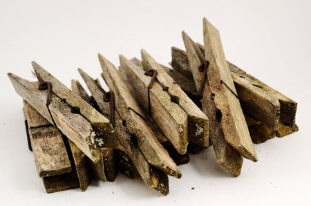 dirty old wooden clothespins on a white backgroundの写真素材