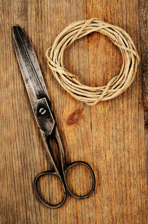 old scissors and hank of packthread on wooden background with Grunge Filterの写真素材