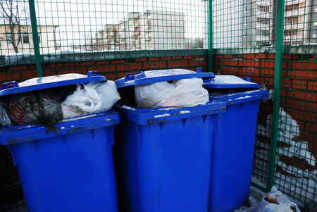 three blue plastic garbage can in yardの写真素材