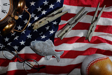 vintage still life, the American flag, an old alarm clock, glasses, baseball, clothespins, fishの写真素材