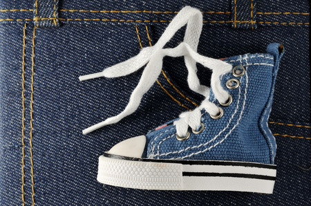 tiny blue shoe on denim background, horizontal