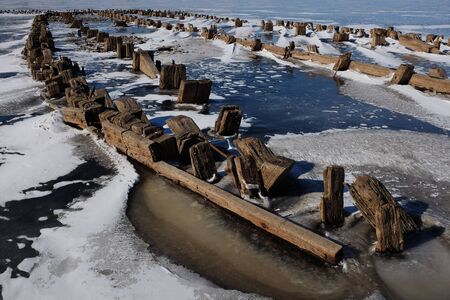 remains of a wooden pier on the lake in winter, landscapeの写真素材