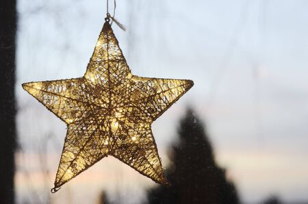 Christmas star on a window against the evening sky