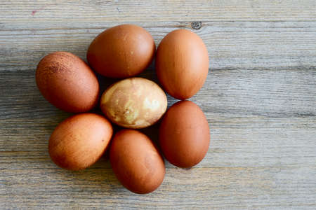 seven painted Easter eggs on a wooden table