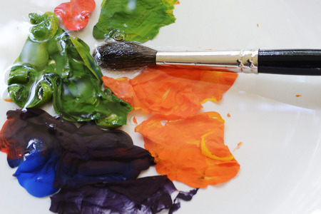 brush and paints on a white plateの写真素材