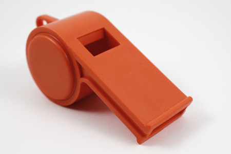 orange plastic whistle on a white background