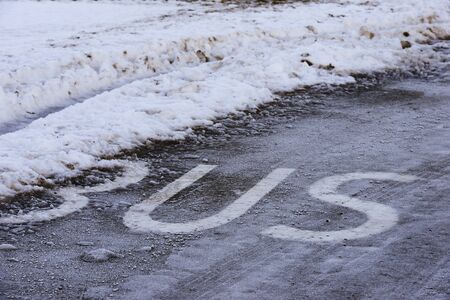 the inscription BUS on the icy road surfaceの写真素材
