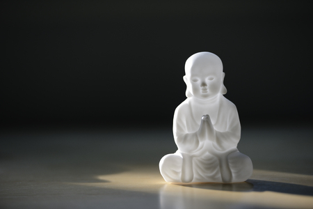plastic small buddha sculpture on the tableの写真素材