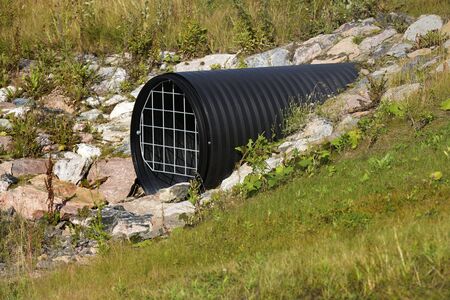plastic corrugated drainage pipe with grate under the roadの写真素材