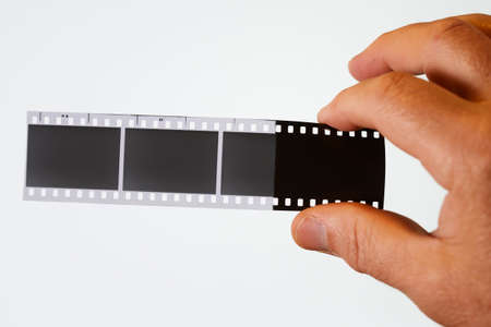 developed negative film in hand on a white backgroundの写真素材
