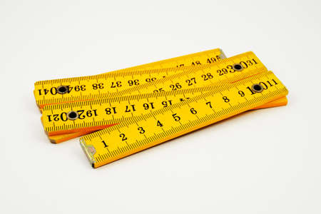 yellow wooden folding rule on white backgroundの写真素材